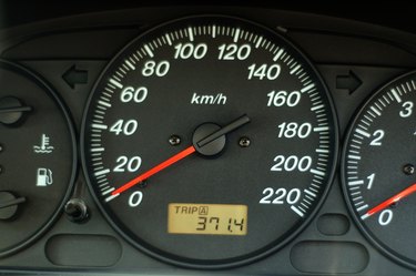 A close up of car dashboard with speed over black background