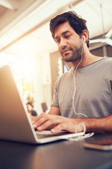 Caucasian man sitting in coffee shop using laptop