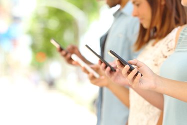 Four friends texting in their smart phones