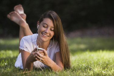 Smiling teenage girl listening to music