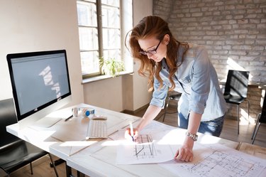 Female designer in office working on architects project